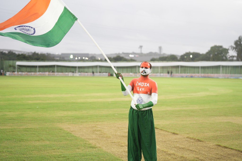 Speaker on stage at evening stadium event with 1919 Sportz branding